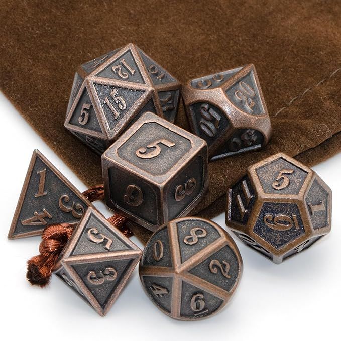 Assorted metal polyhedral dice in bronze and gray on a brown surface with a few showing numbered faces