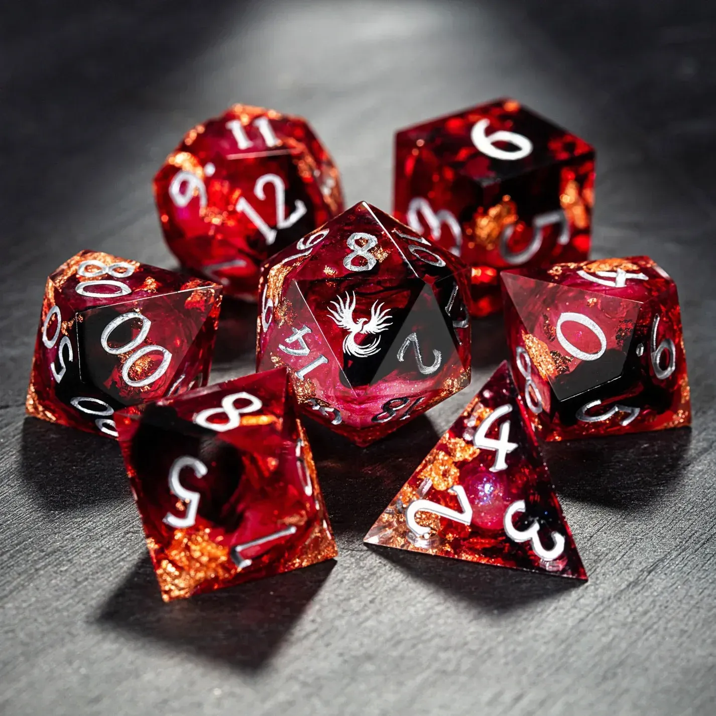 Red translucent polyhedral dice scattered on a dark surface, with white numbers and symbols.
