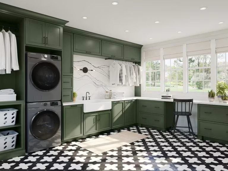 Modern laundry room with green cabinets, stacked washer-dryer, white countertops, and black-and-white patterned floor