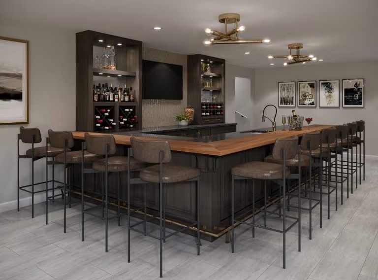 Modern home bar with dark wood counters, high stools, shelves, and framed wall art