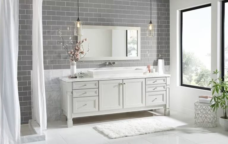 Bright modern bathroom with white vanity, large mirror, gray tile wall, and black-framed windows