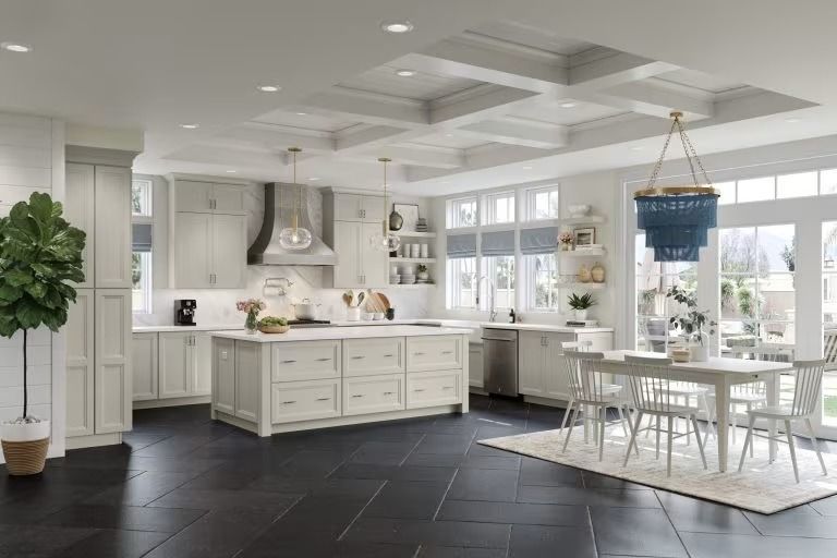 Bright white open-plan kitchen and dining room with island, large windows, and black tiled floor