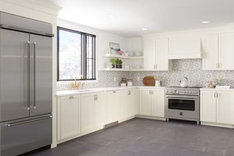 Bright modern kitchen with white cabinets, stainless appliances, and a large window