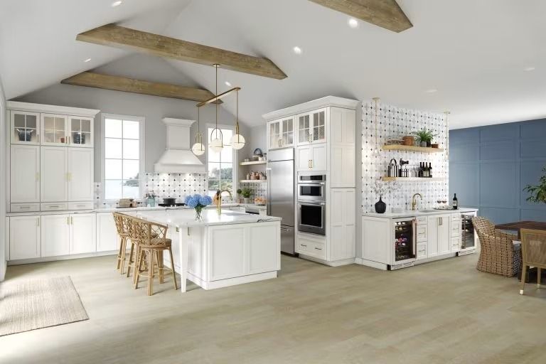Bright modern kitchen with white cabinetry, island, wood beams, and light blue accent wall