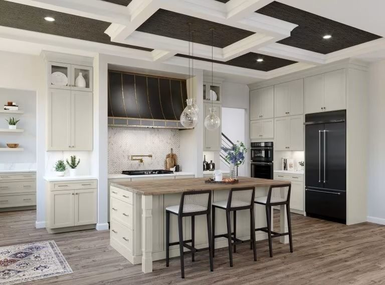 Modern white kitchen with island, black barstools, and stainless appliances under tray ceiling lights