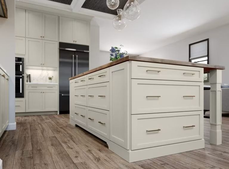 Bright modern kitchen with white cabinets, wood floor, and a large island with drawers and a countertop