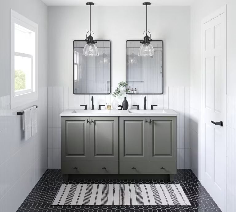 Modern bathroom with gray vanity, dual mirrors, black pendant lights, and striped floor rug.
