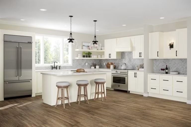 Bright modern kitchen with white cabinets, island, stainless fridge, and wood floors