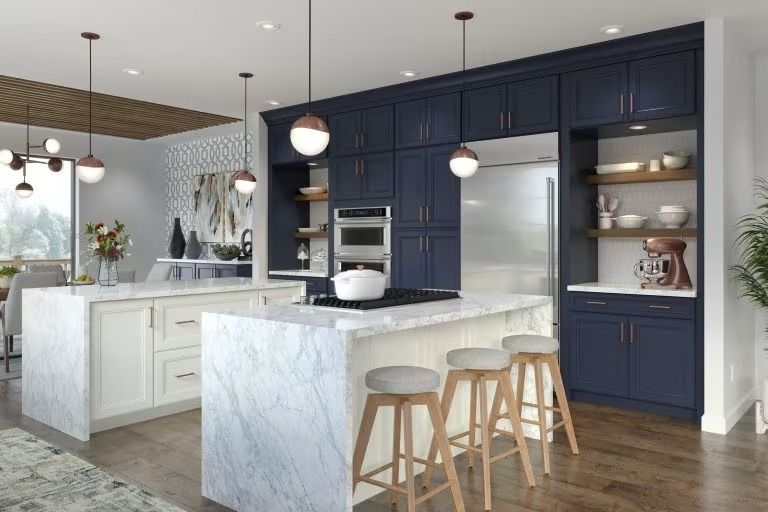 Modern kitchen with navy cabinets, white marble island, pendant lights, and wood floors