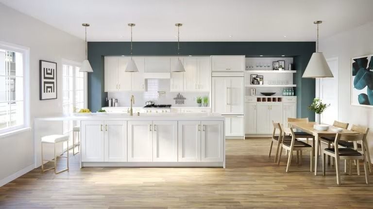 Bright modern kitchen and dining area with white cabinets, wood floors, and hanging pendant lights