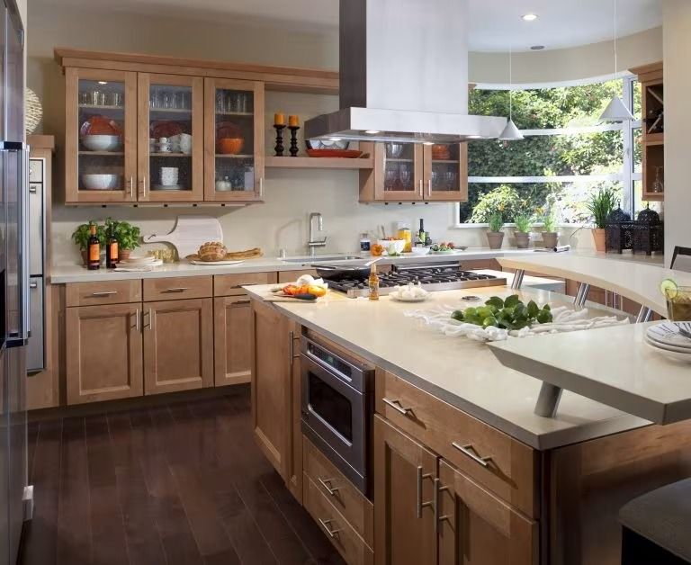 Modern kitchen with wood cabinets, large island, stainless range hood, and bright window over the sink