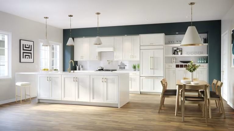 Bright white open-plan kitchen and dining area with pendant lights, island, and wooden table with chairs
