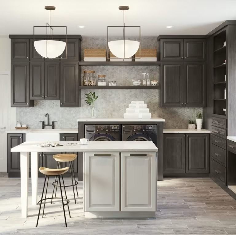 Modern kitchen with dark cabinets, white island, pendant lights, and bar stools