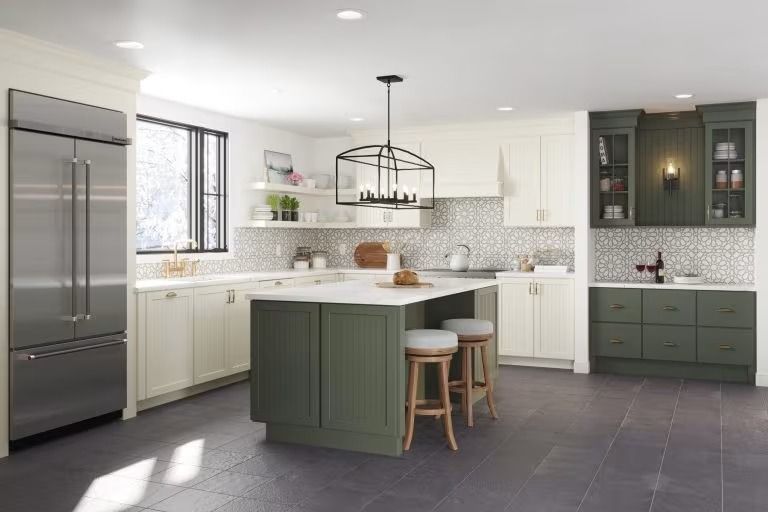 Bright modern kitchen with white cabinets, green island and lower cabinets, stainless fridge, and tiled floor