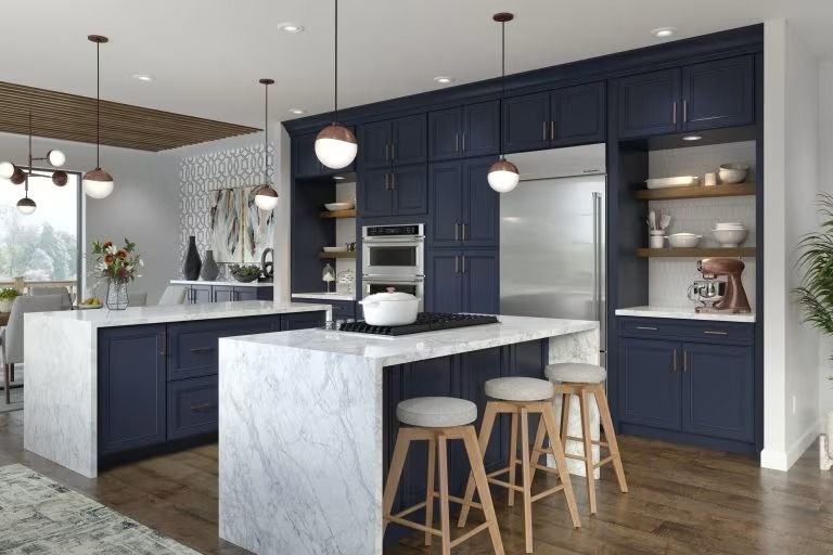 Modern navy kitchen with marble island, pendant lights, and wood floors