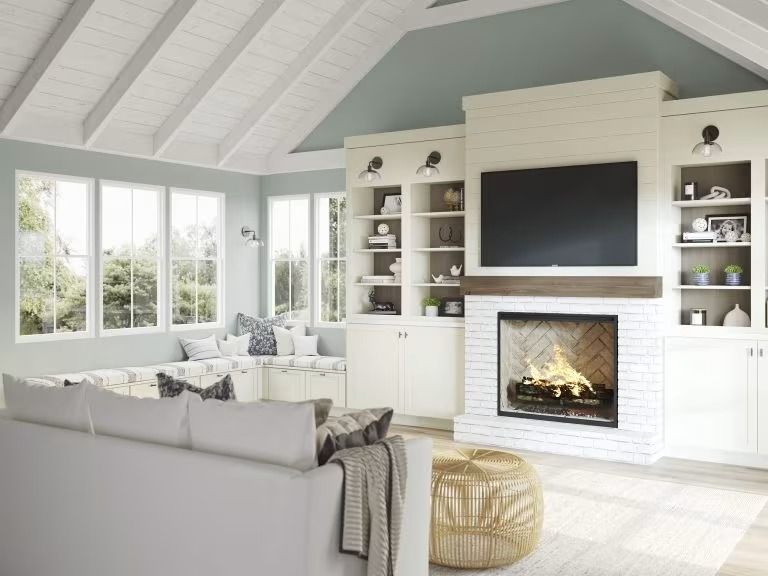 Bright modern living room with white fireplace, large TV, sectional sofa, and plenty of natural light.