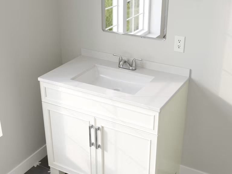 White bathroom vanity with sink and mirror in a bright corner alcove