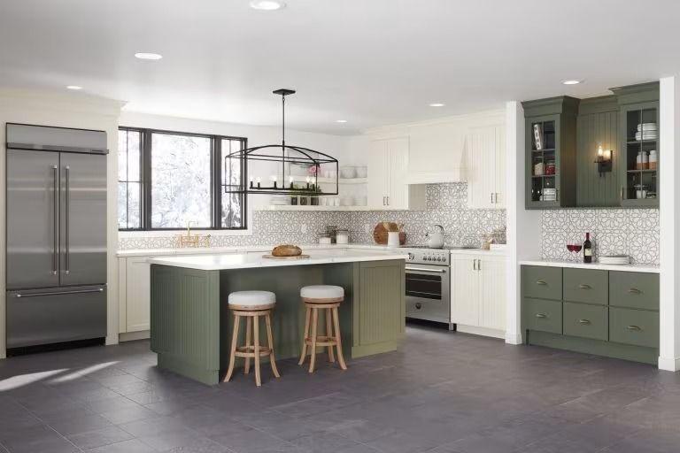 Modern white kitchen with green island, stainless appliances, and pendant lighting