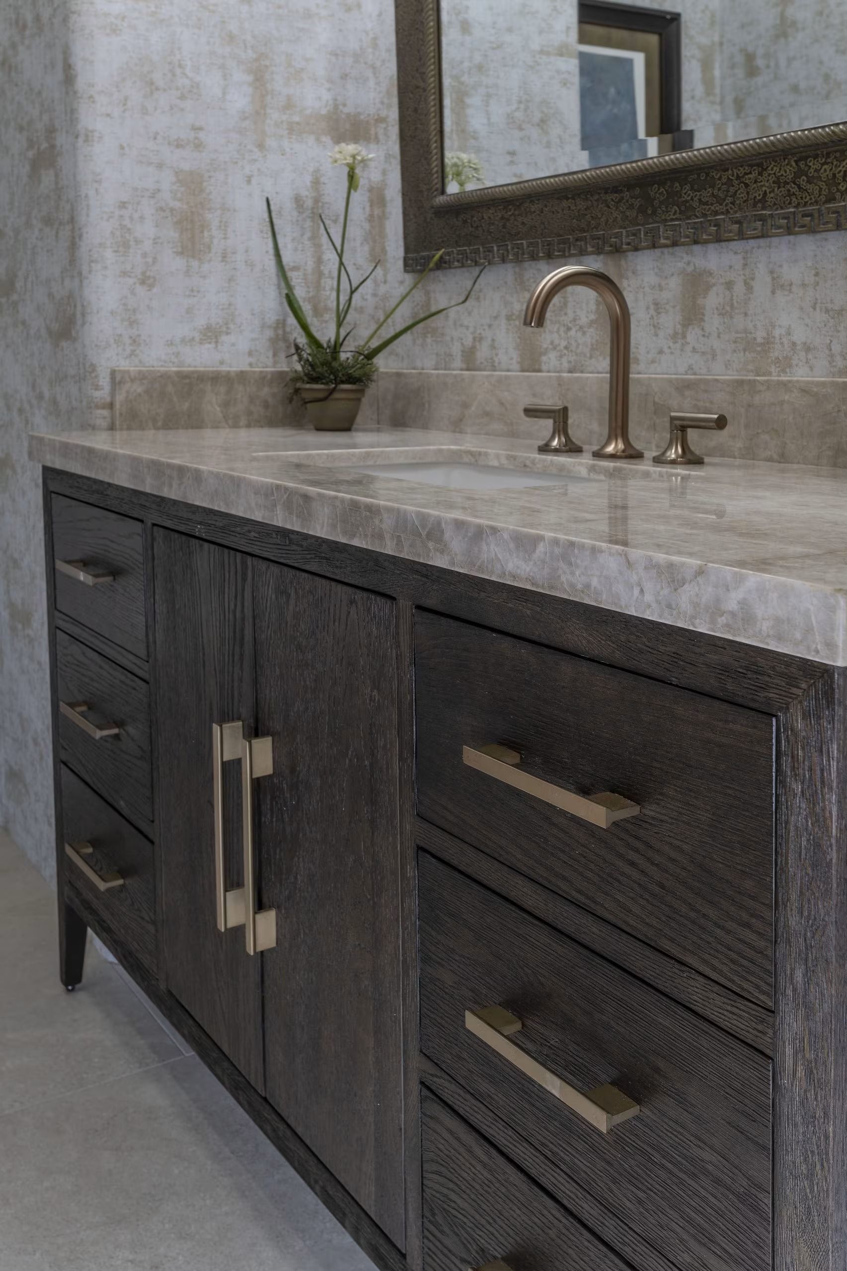 Modern dark wood bathroom vanity with stone countertop, double drawers, sink, and mirror.