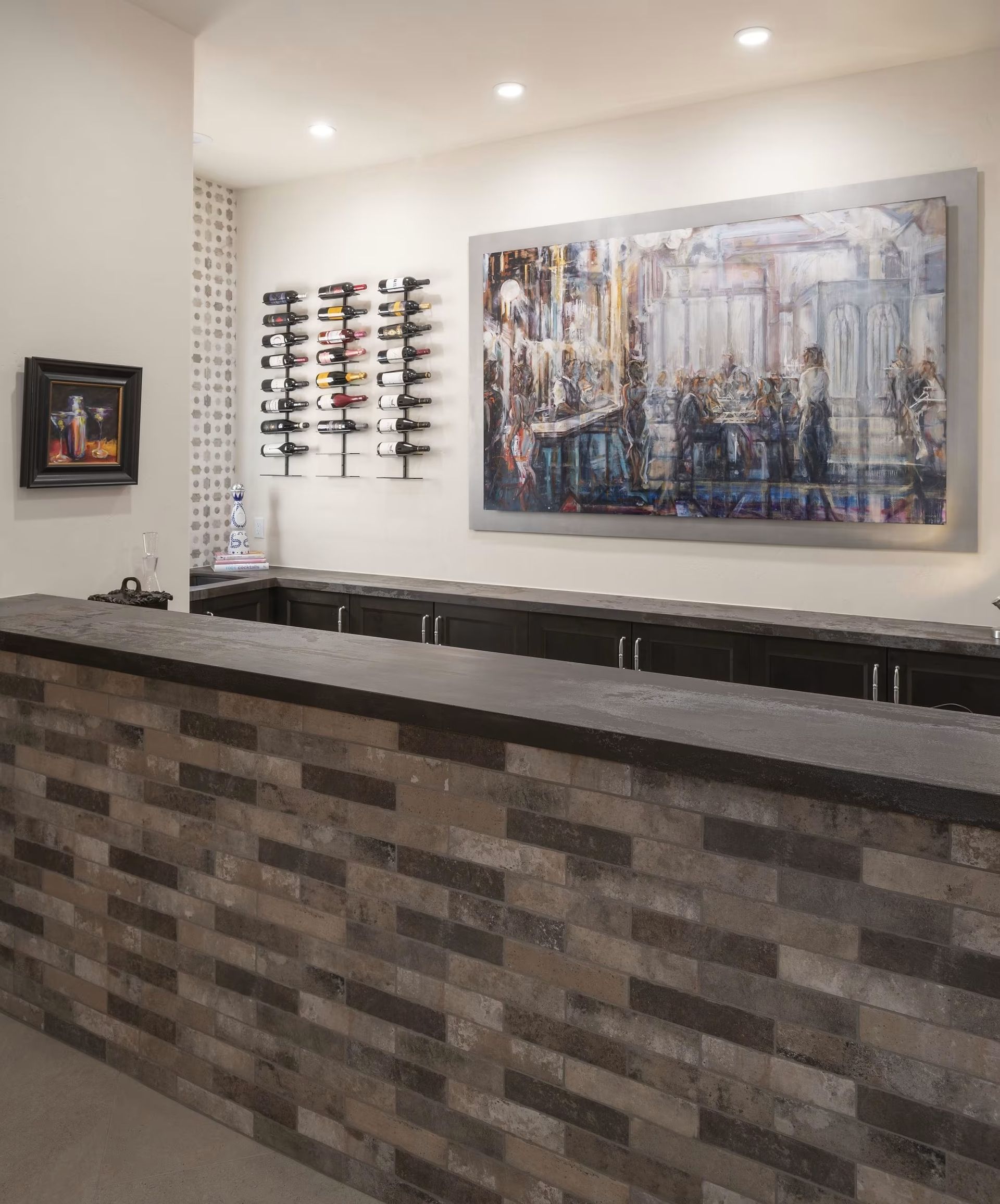Modern hotel reception desk with stone front, wall art, wine display, and soft recessed lighting.