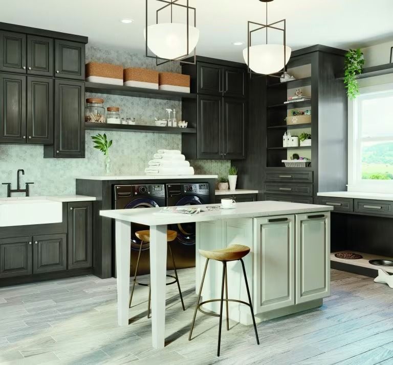 Modern kitchen with dark cabinets, white island, pendant lights, and light wood flooring