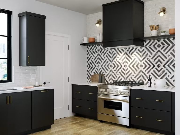 Modern kitchen with black cabinets, stainless stove, white countertops, and black-and-white geometric backsplash