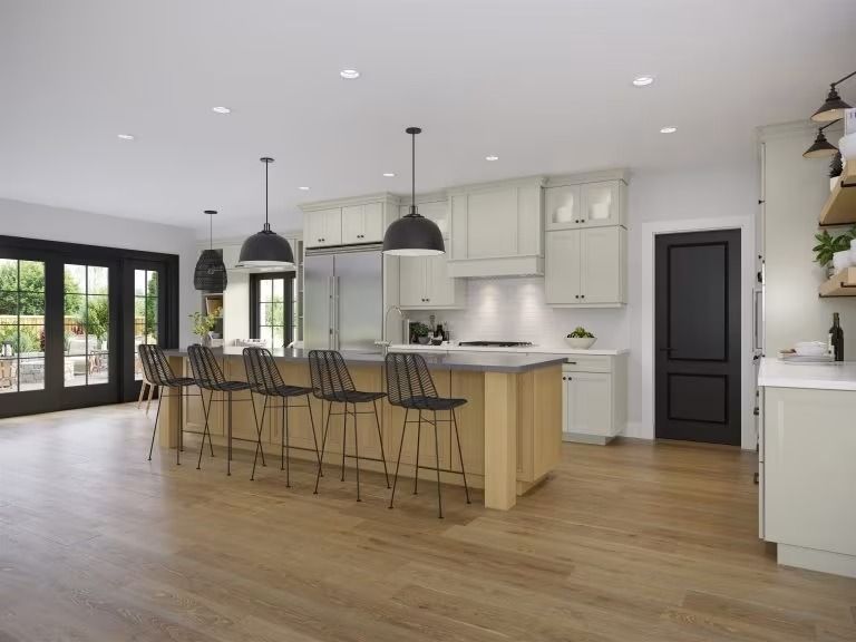 Modern kitchen with island, bar stools, pendant lights, and wood floors in a bright open room