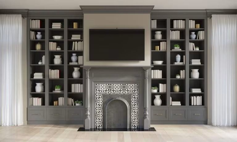 Elegant living room with built-in shelves, a large TV, and a decorative fireplace centered on the wall