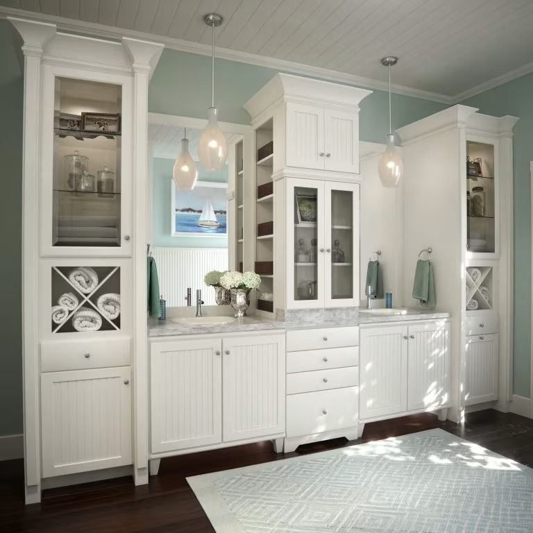 White built-in cabinets and glass-front storage in a bright, modern living room with pendant lights.
