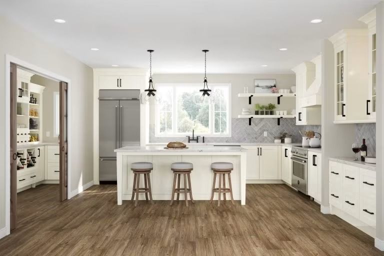 Bright modern kitchen with white cabinets, island seating, and wood flooring