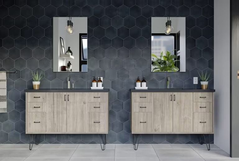 Modern bathroom vanity with twin sinks, mirrors, wood cabinets, and dark hexagonal tile walls