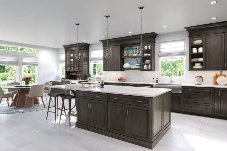 Bright modern kitchen with dark cabinets, white island, and dining area by large windows