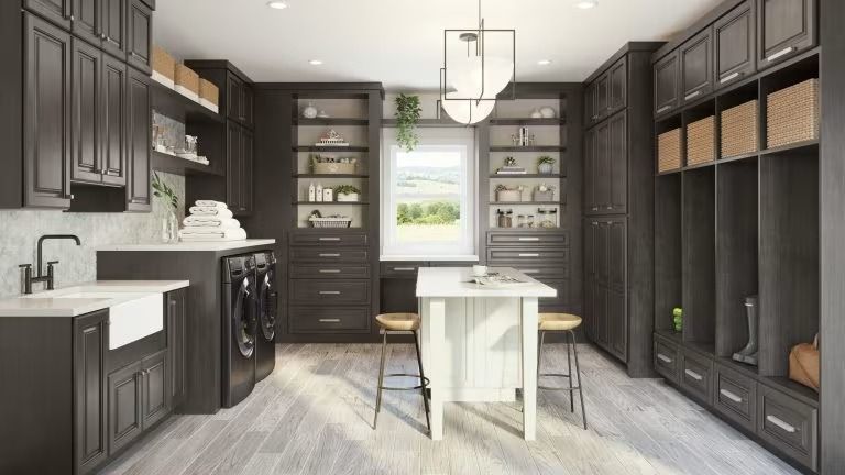 Modern dark gray kitchen with white island, farmhouse sink, open shelving, and pendant light