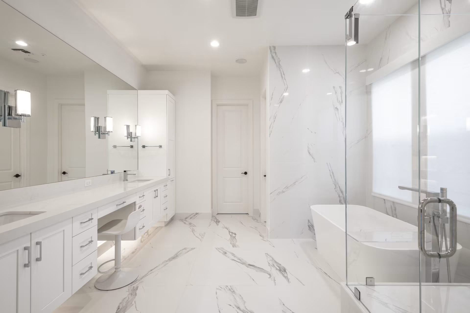 Bright modern white bathroom with double vanity, large mirror, and glass shower