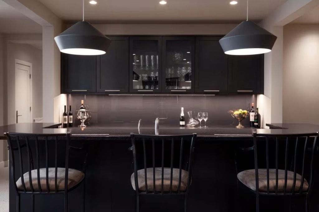 Modern kitchen with dark cabinetry, island seating, pendant lights, and glass-front cabinets
