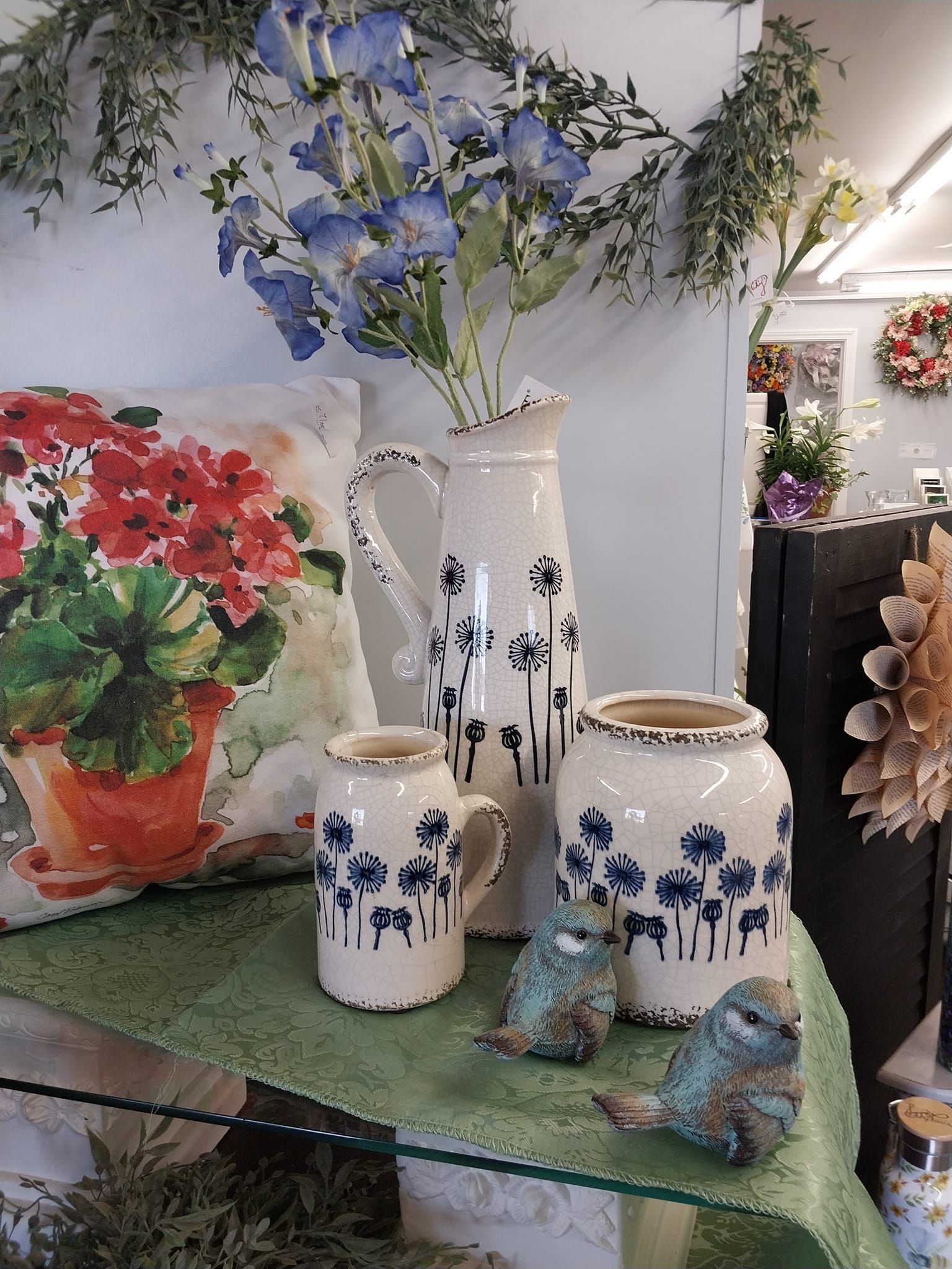 A table with vases and a pillow with flowers on it