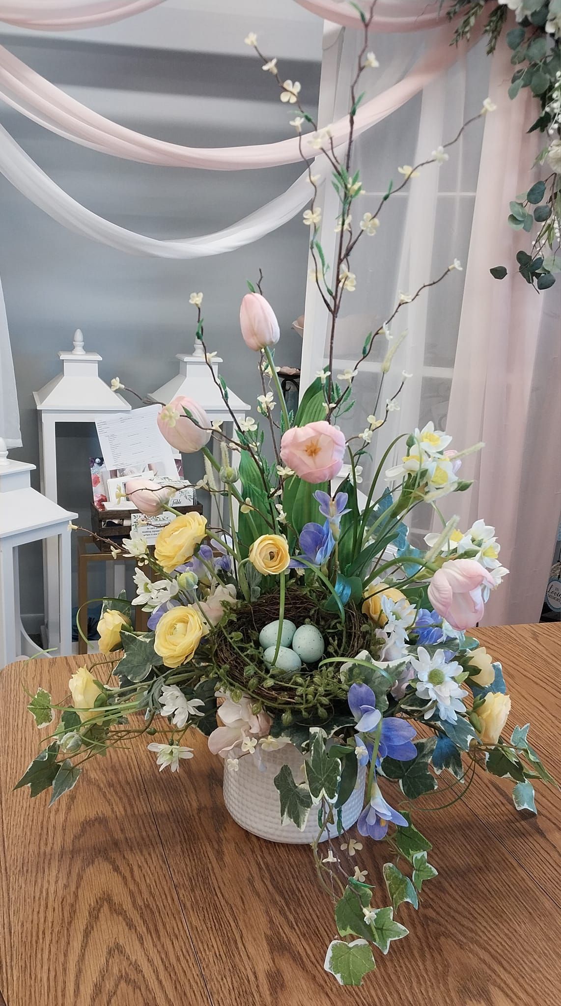 A vase filled with flowers is sitting on a wooden table.
