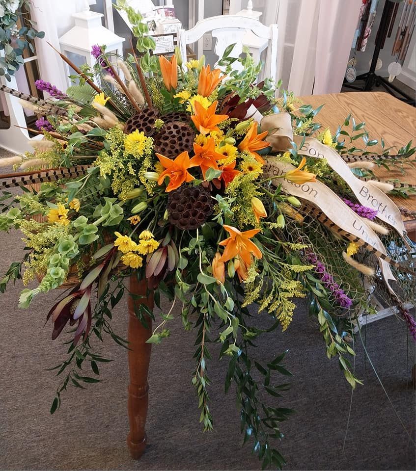 A bunch of flowers on a table with a ribbon that says 