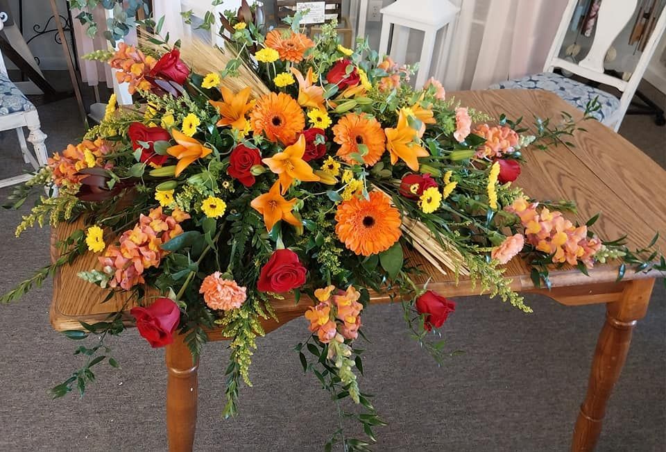 A wooden table with a bunch of flowers on it