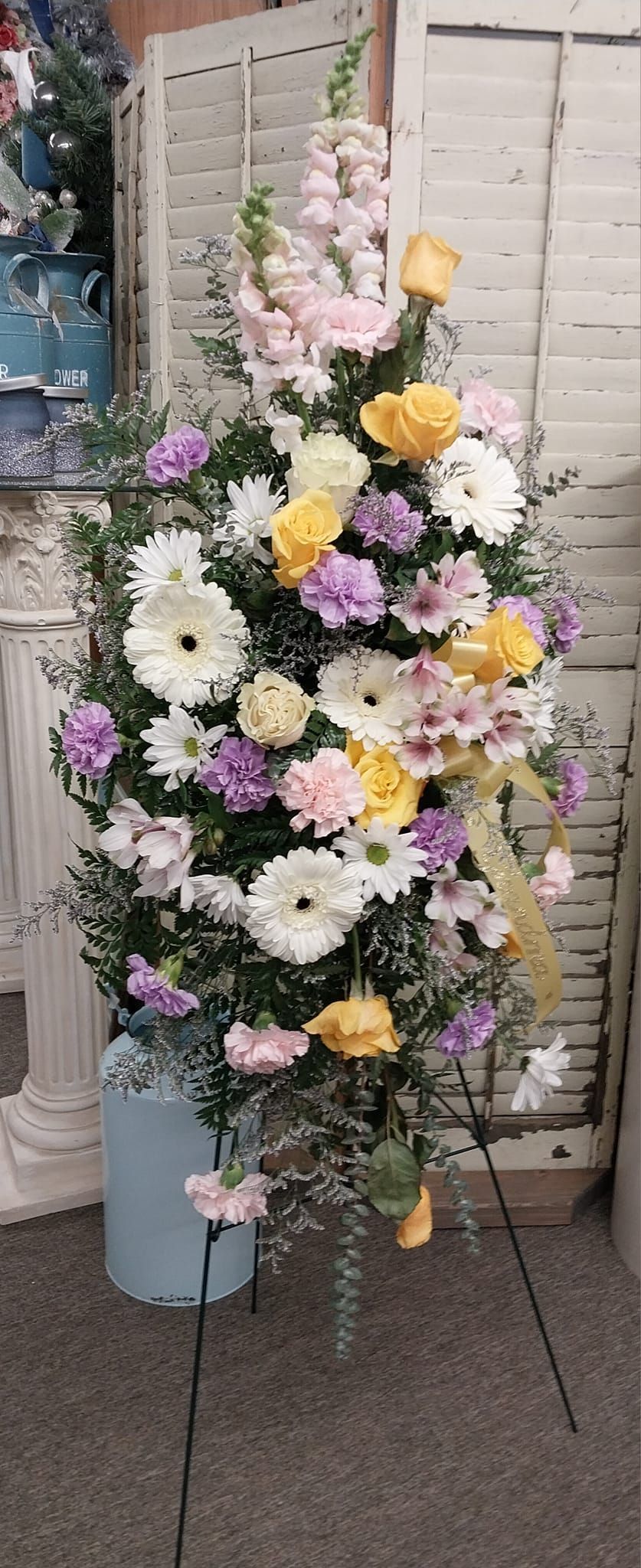 A bouquet of flowers is sitting on a stand in a room.