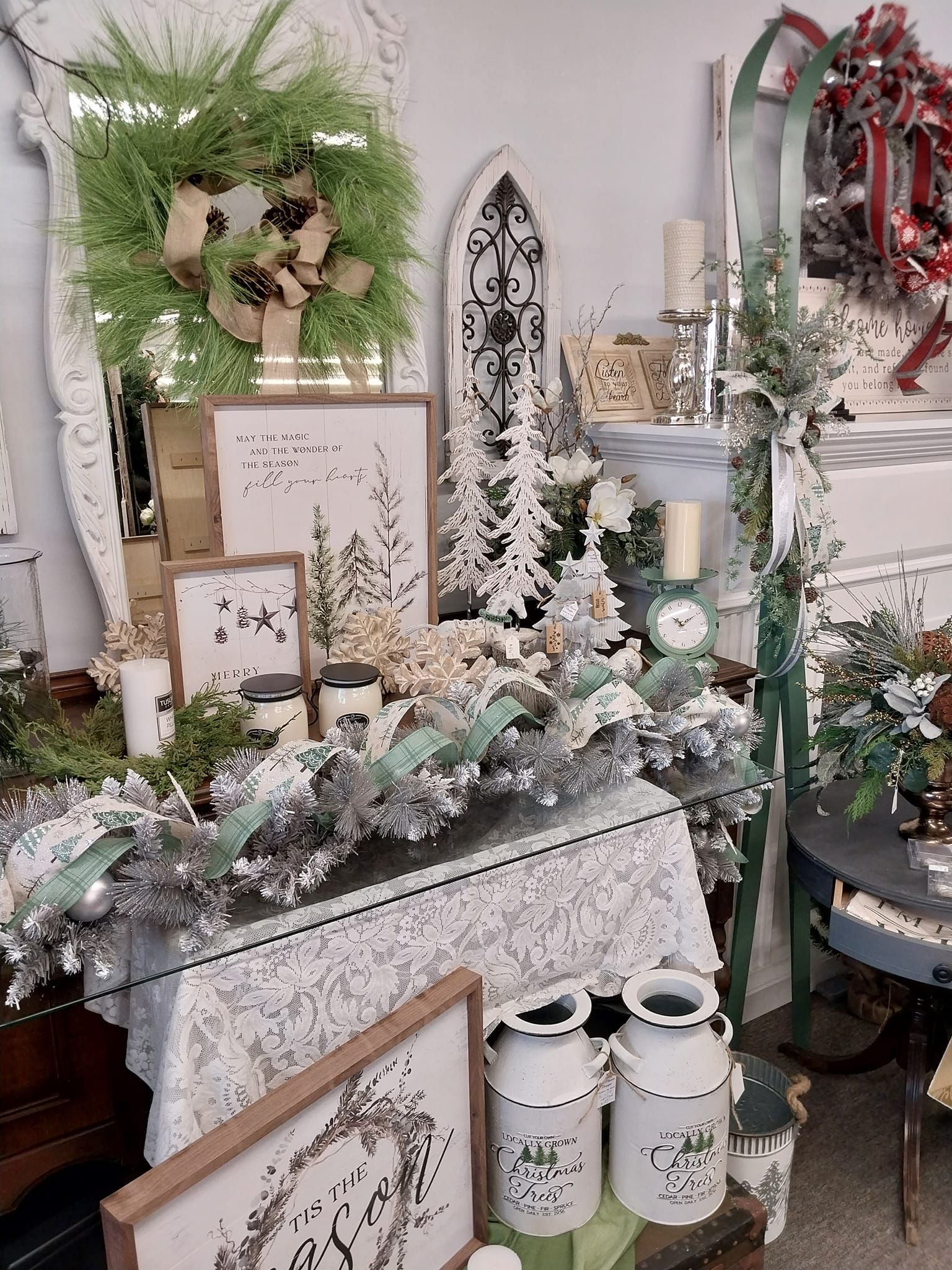A living room filled with lots of christmas decorations , including a christmas tree and a wreath.