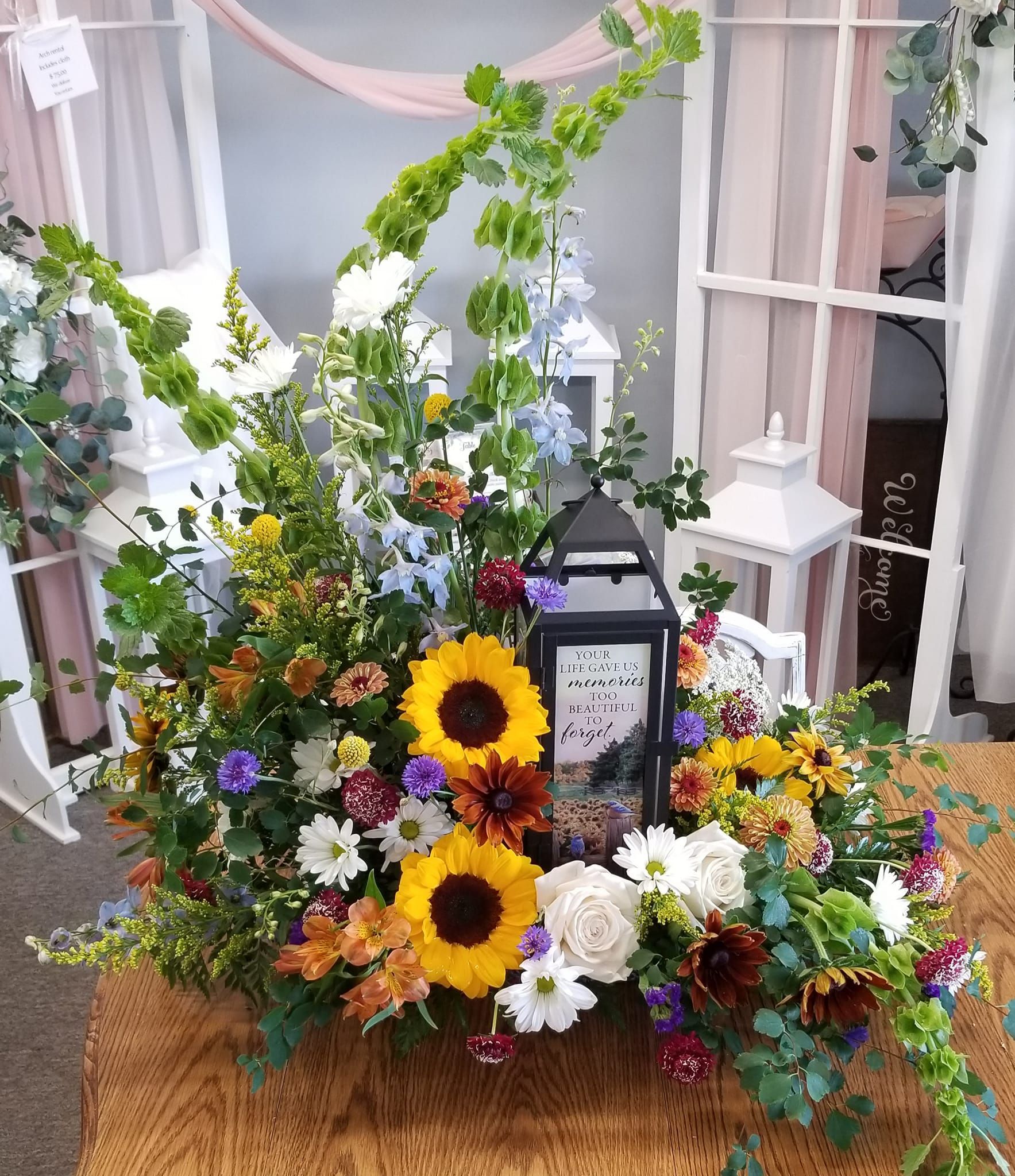 A lantern is surrounded by flowers on a table