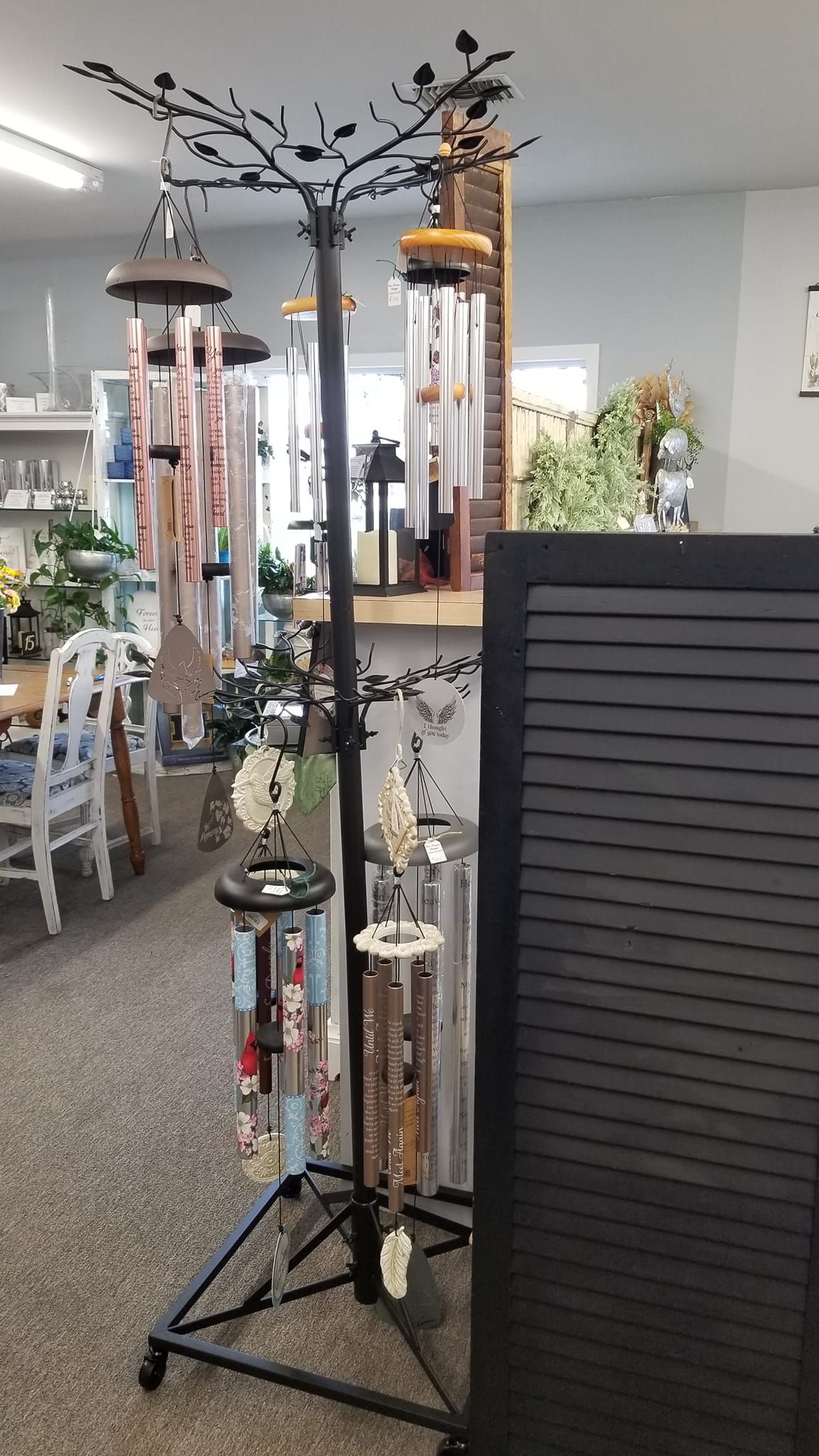 A display of wind chimes on a stand in a store.