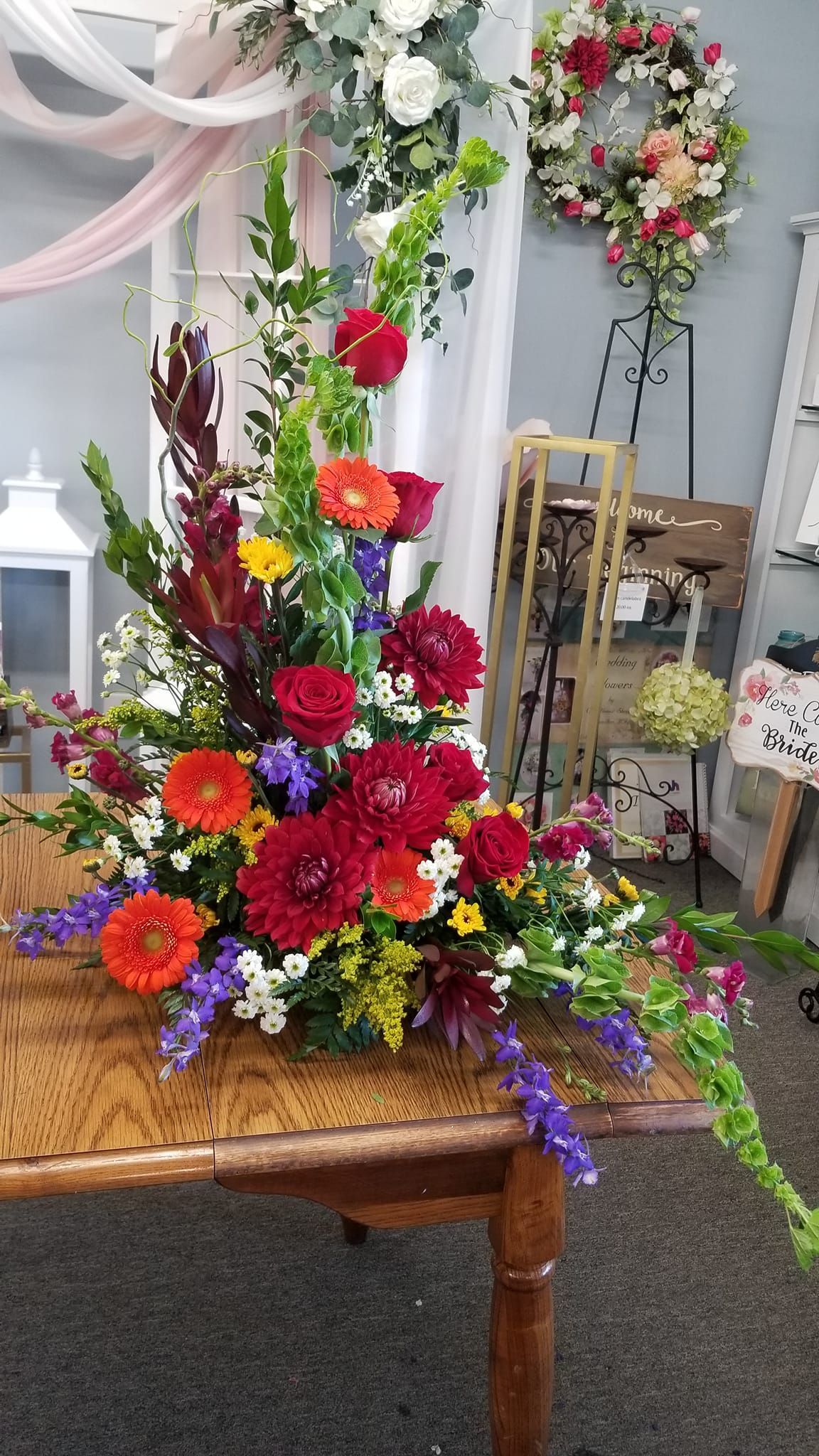 A large flower arrangement is sitting on a wooden table.