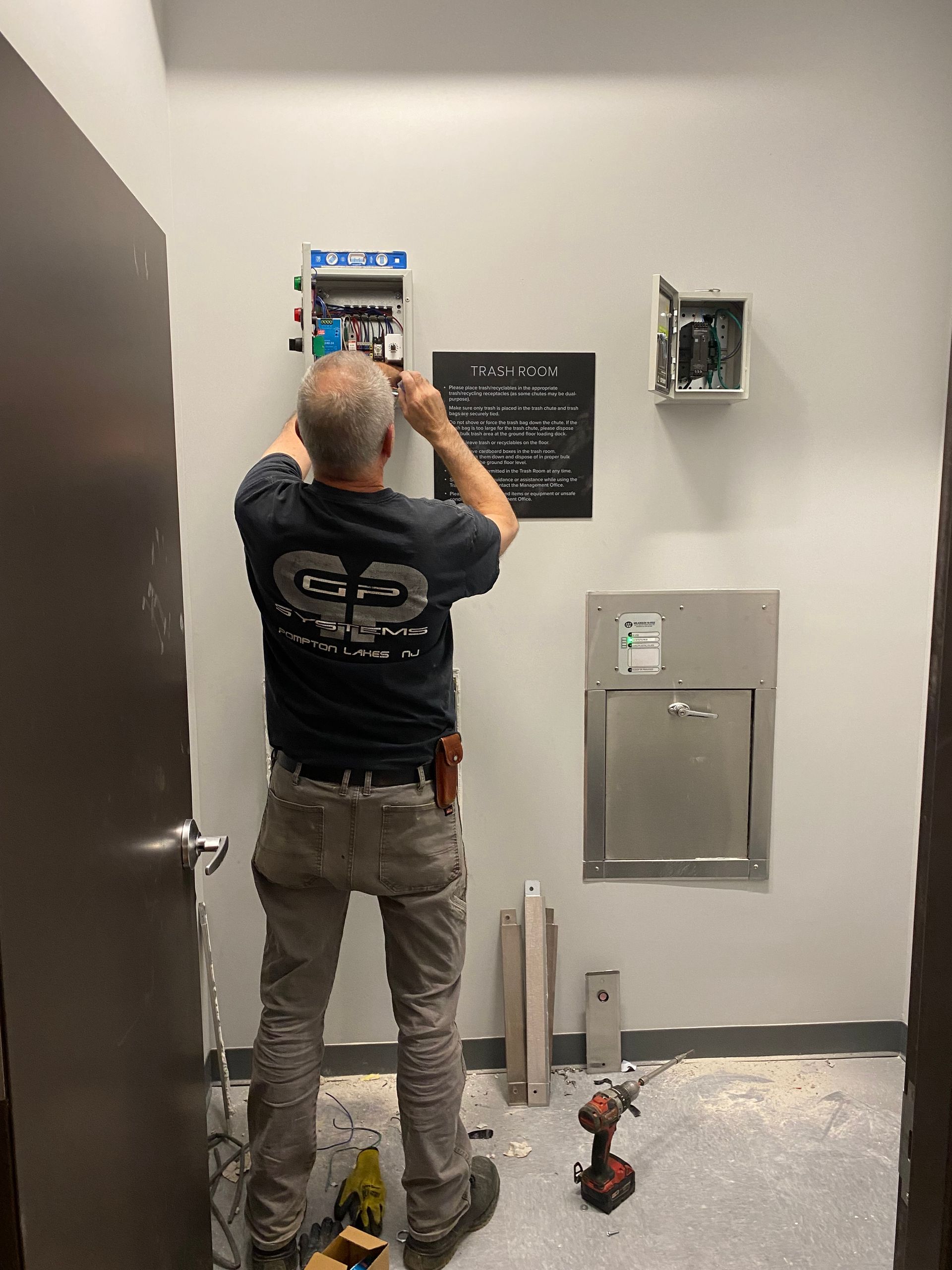 Electrician working on a panel inside a room with a water fountain.
