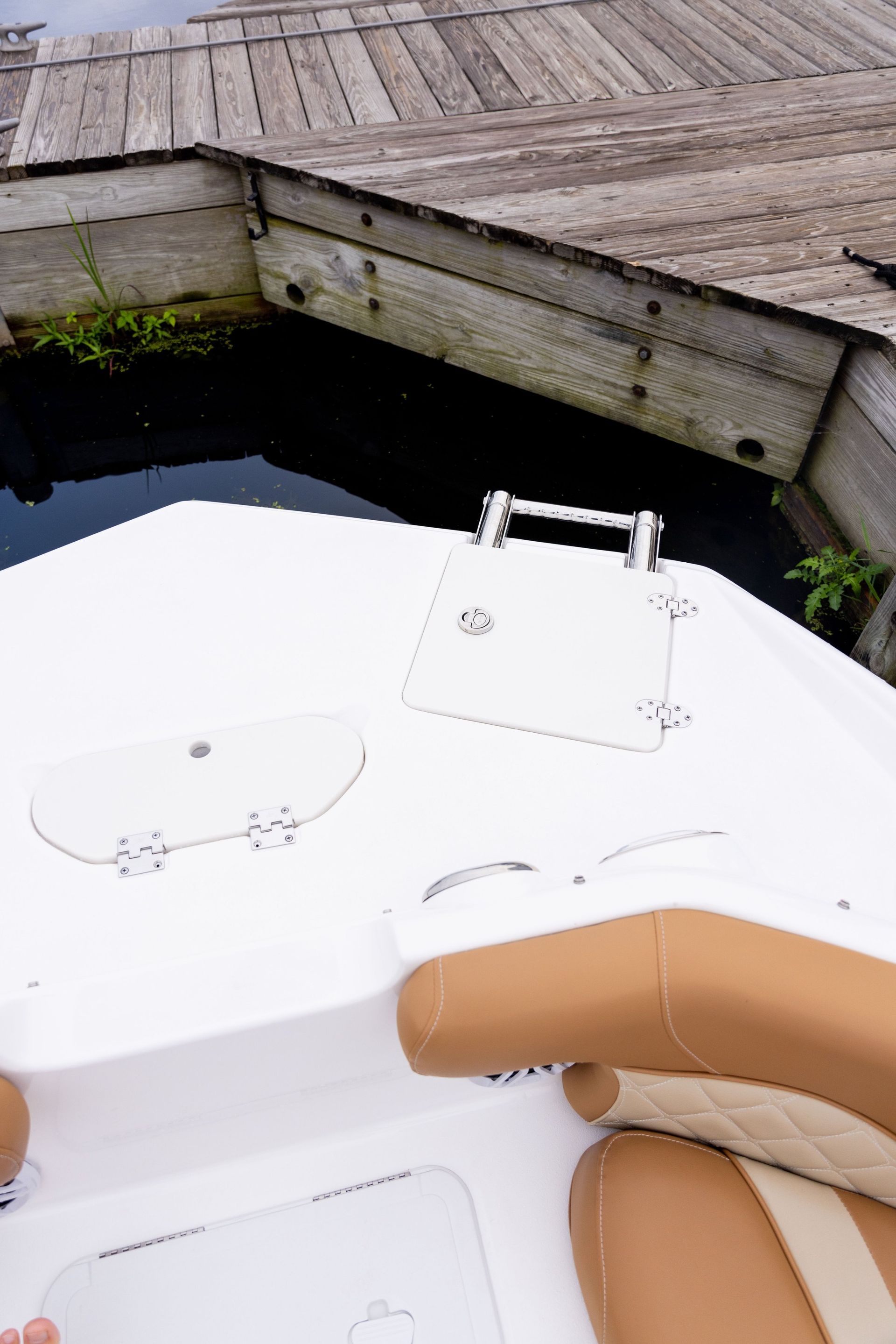 A boat is docked at a dock next to a body of water.