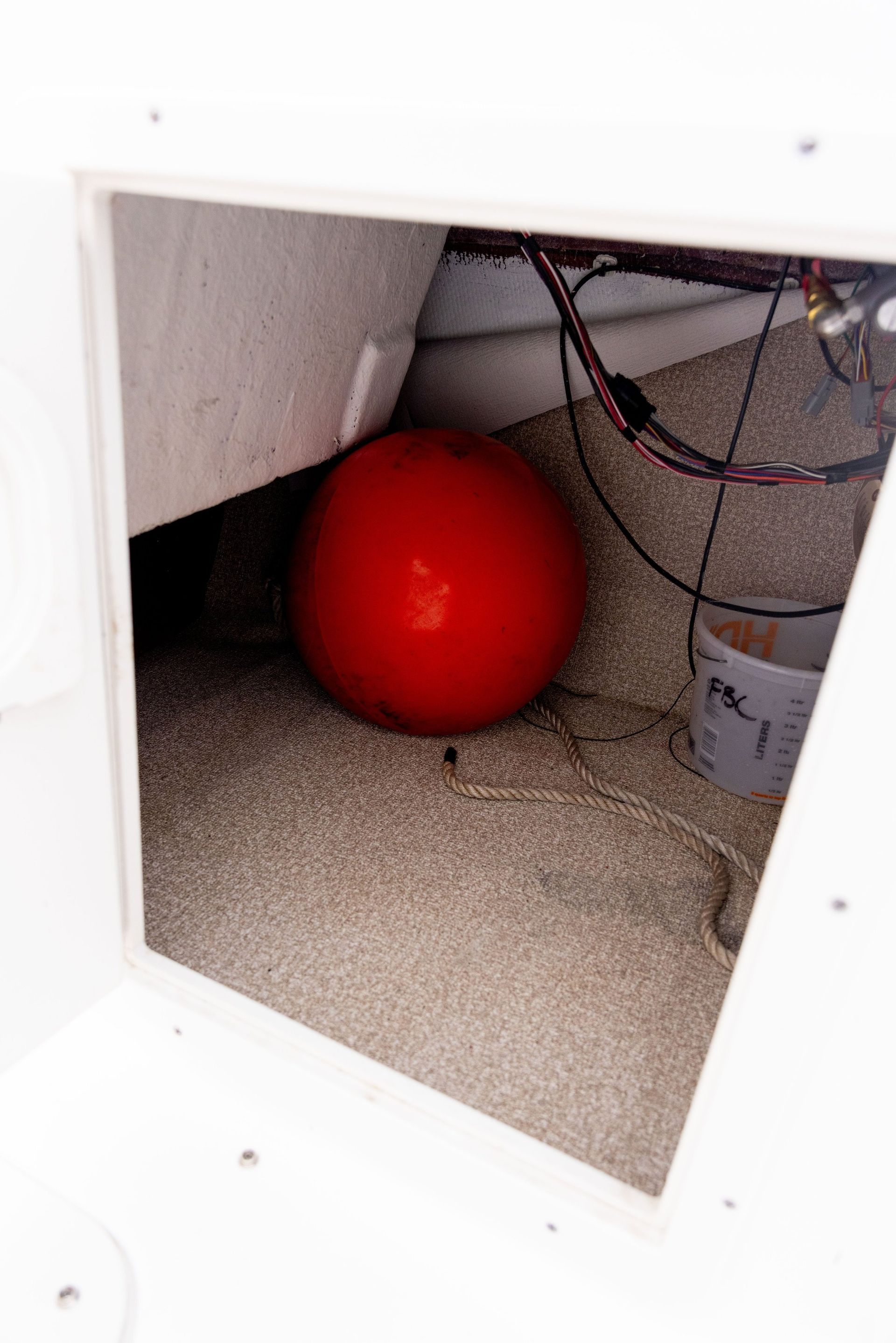 A red ball is sitting in the corner of a room.