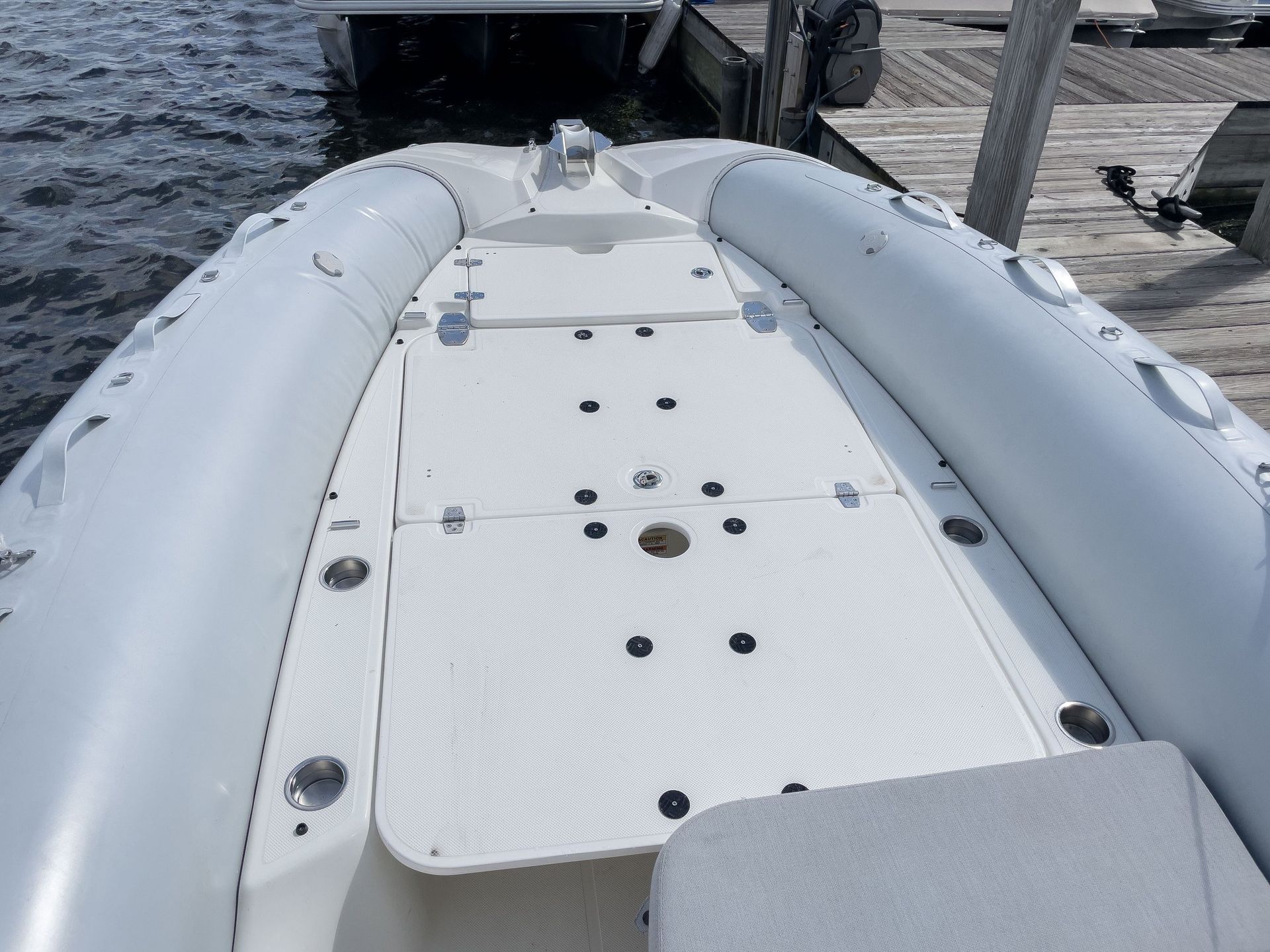 A white boat is docked at a dock in the water