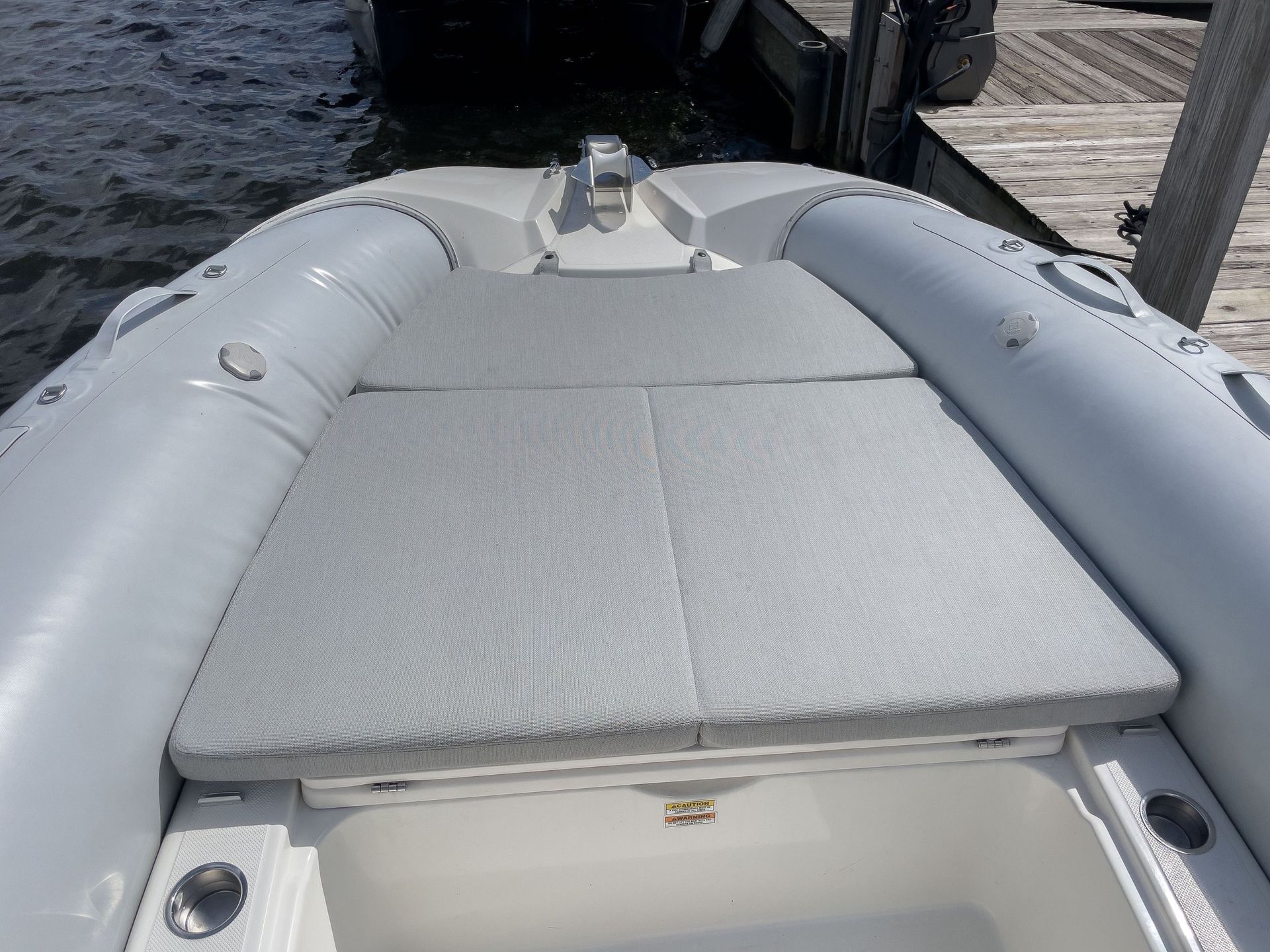 A boat is docked at a dock with a cushion on the back of it.