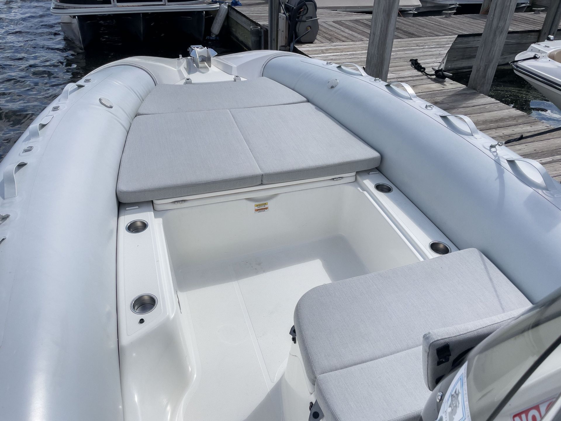 A white inflatable boat is docked at a dock.